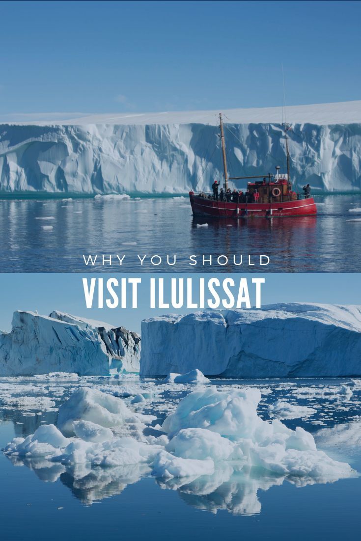 an iceberg floating in the ocean next to a red boat with people on it