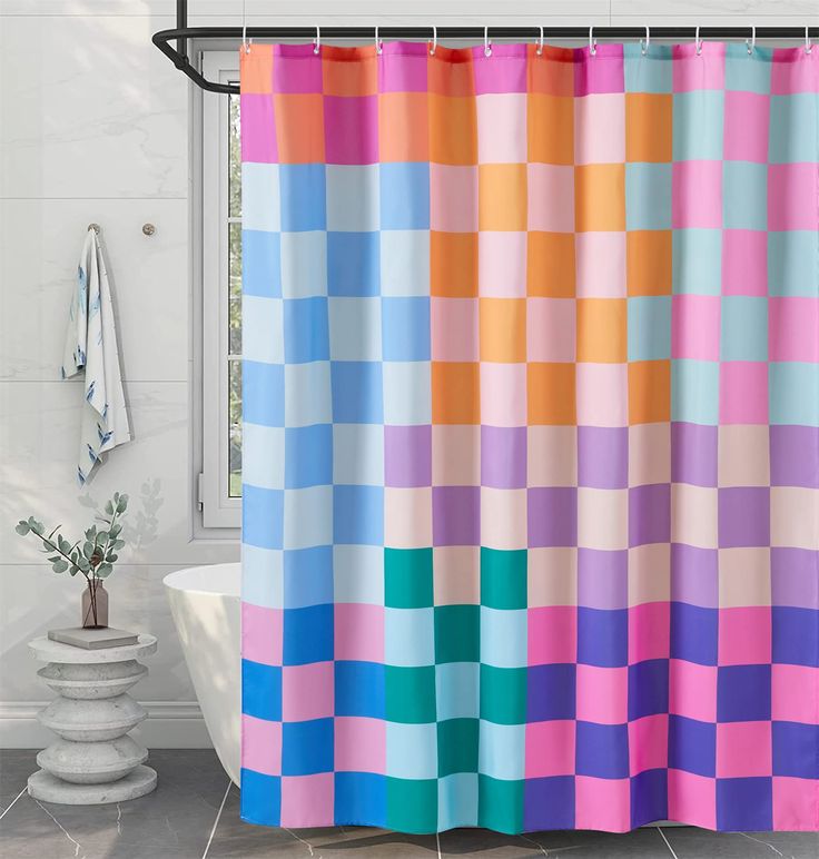 a bath room with a tub and a shower curtain that has different colored squares on it