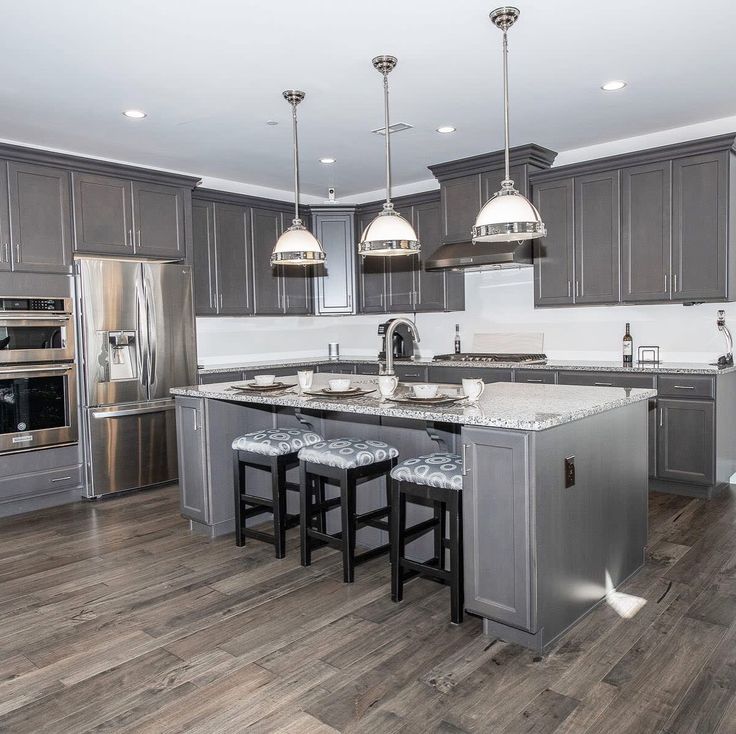 a large kitchen with gray cabinets and stainless steel appliances