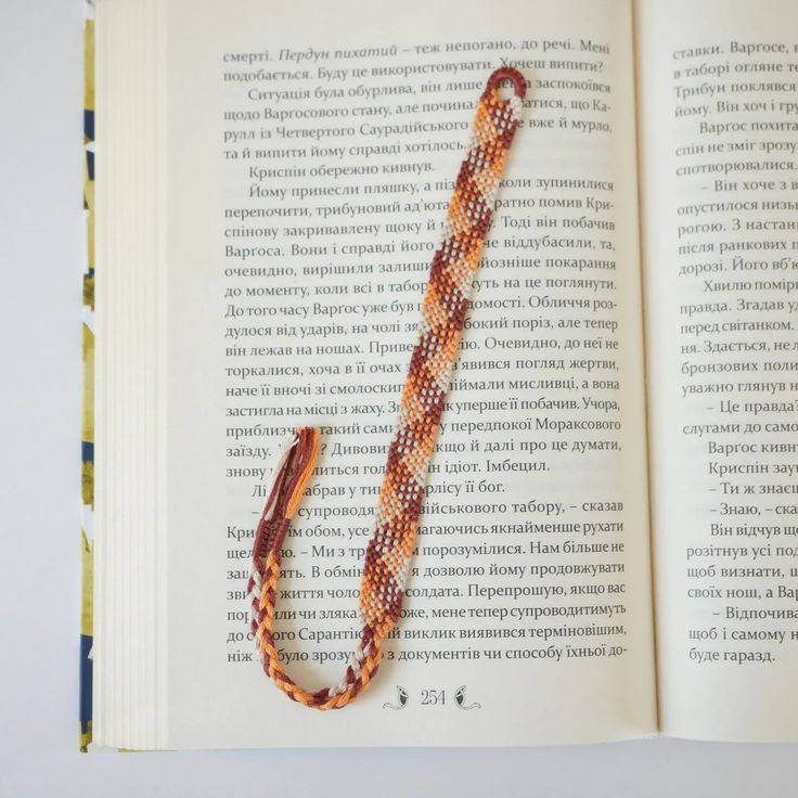 an open book with a beaded bracelet on it