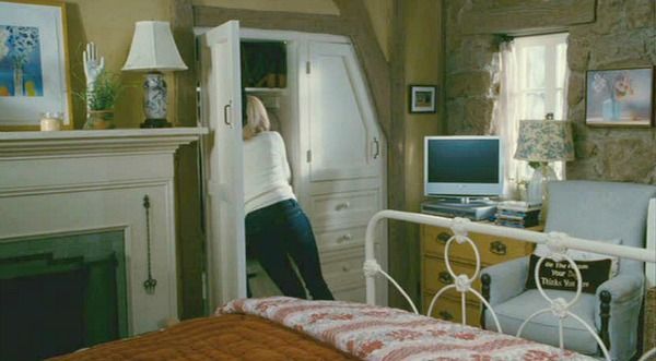 a woman standing in the doorway of a bedroom