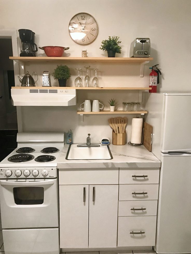 a kitchen with white appliances and wooden shelves