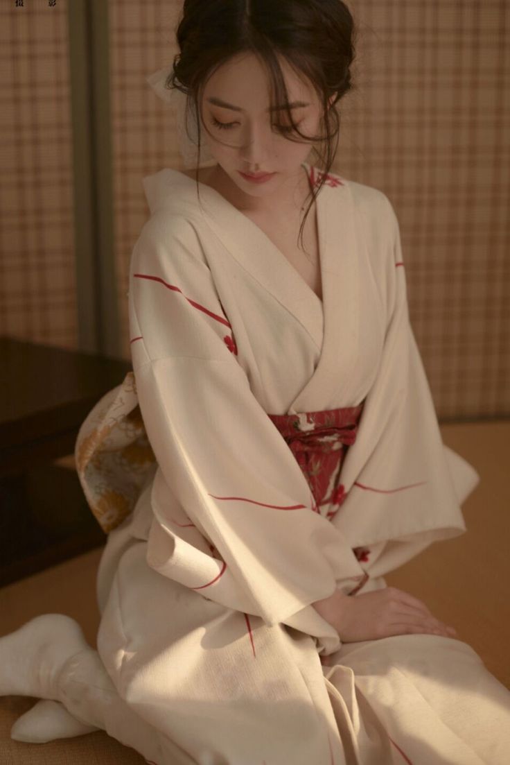 a woman in a kimono sitting on a bed