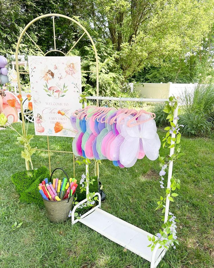 an outdoor display with balloons and streamers in the grass next to a potted plant