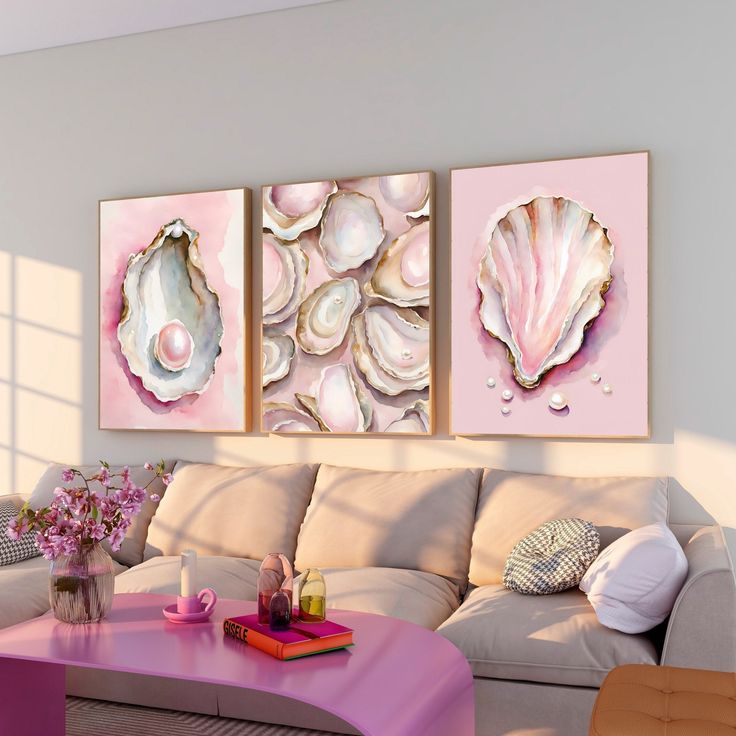 three seashell paintings hang on the wall above a white couch in a living room