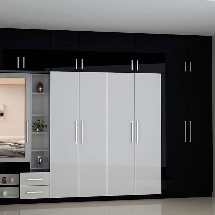 a bedroom with black and white cabinets and drawers