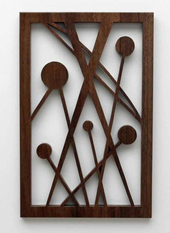 a piece of art made out of wood with circles and spoons in the center