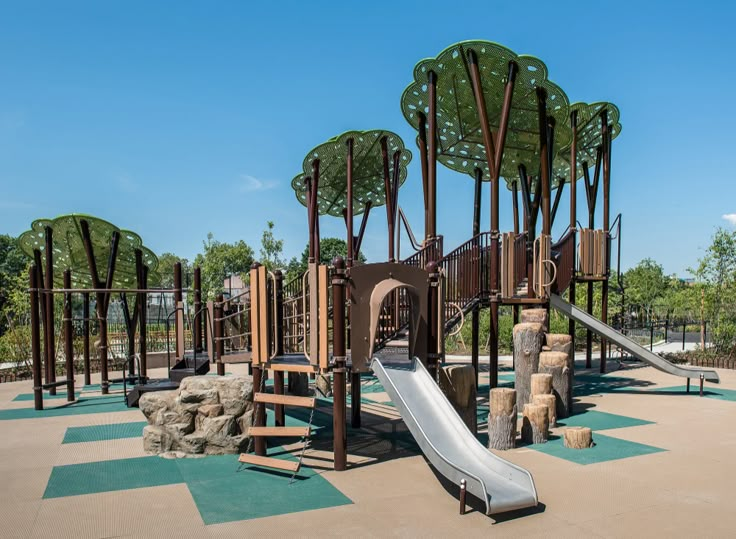 an outdoor play area with trees, rocks and a slide