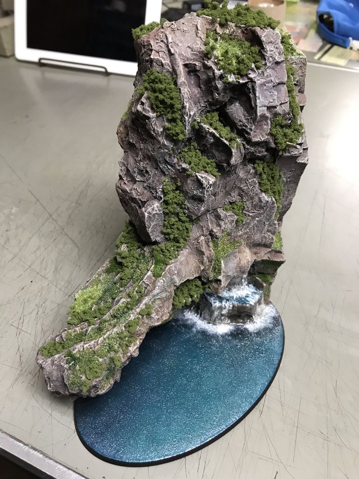 a rock covered in moss sitting on top of a table