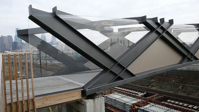 the roof of a building that is being constructed with steel beams and glass coverings