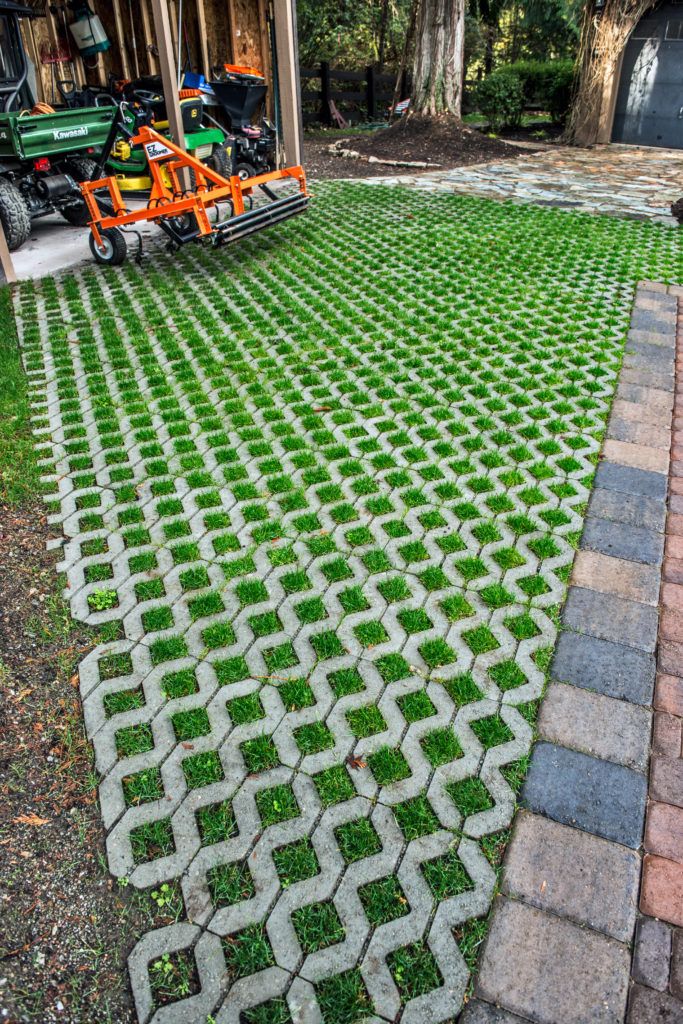 a lawn that has been laid out with green grass and brick pavers on it