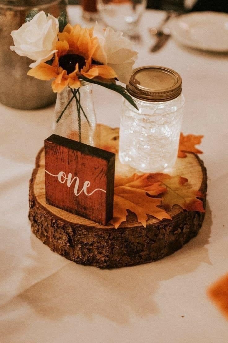 there is a vase with some flowers in it on the wooden slice at the table