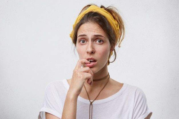 a woman making a funny face while holding her hand to her mouth