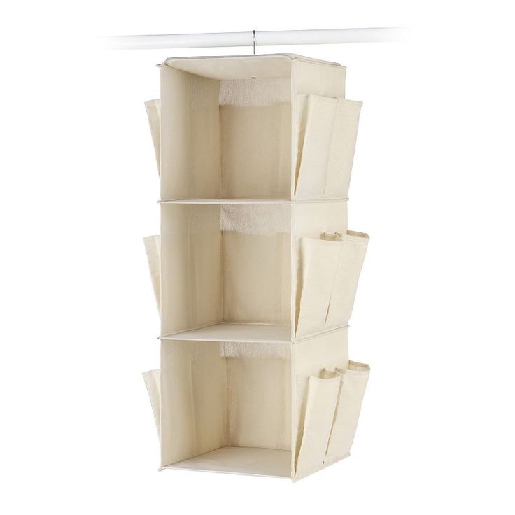 the hanging shelf is made out of canvas and has three bins on each side