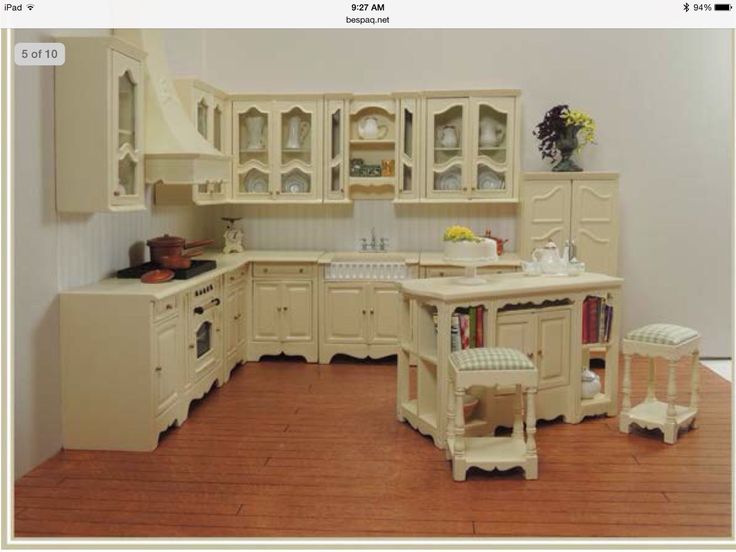 a model kitchen with white cabinets and wooden floors