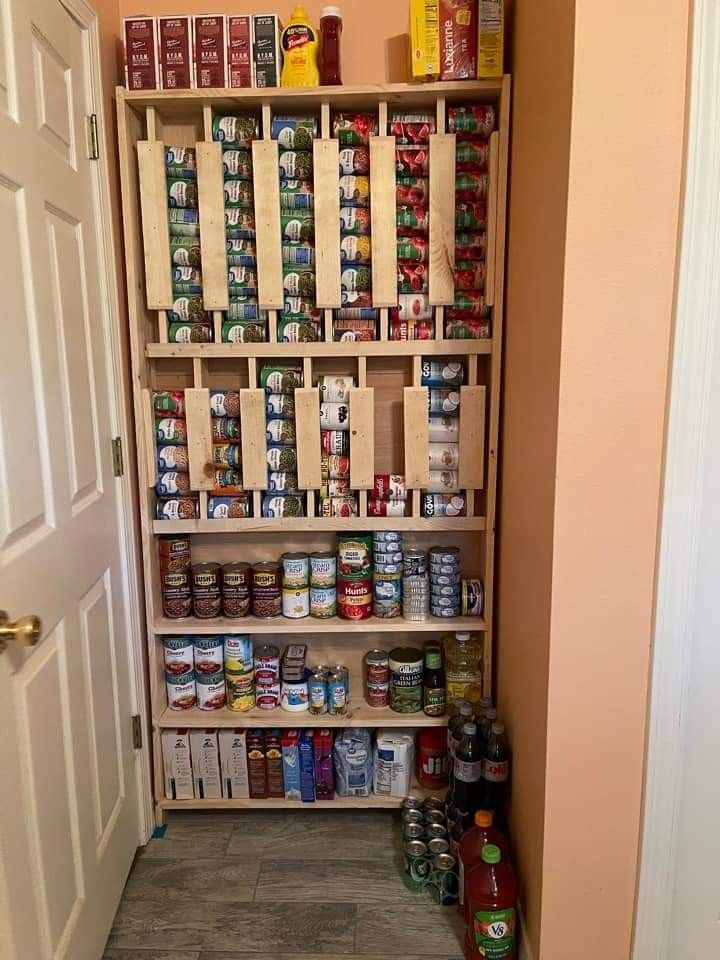 an open pantry with canned food and condiments on the shelves next to it