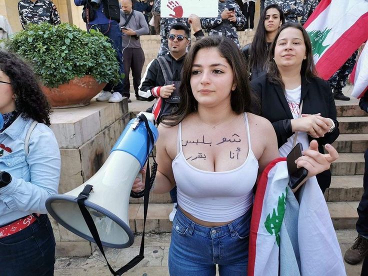 a group of women holding flags and megaphones in front of some steps with other people