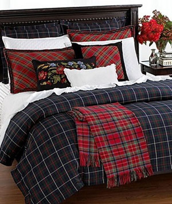 a bed with plaid comforter and pillows on it