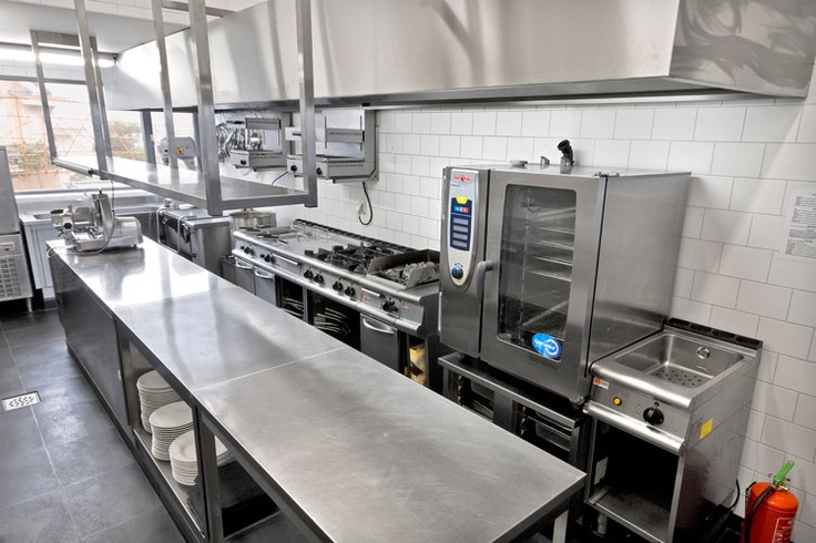 an industrial kitchen with stainless steel counters and appliances