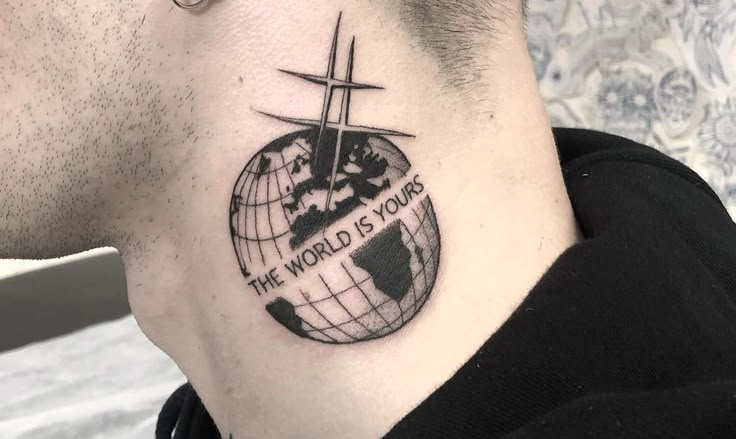 a man's neck with a tattoo on it that says the world is yours