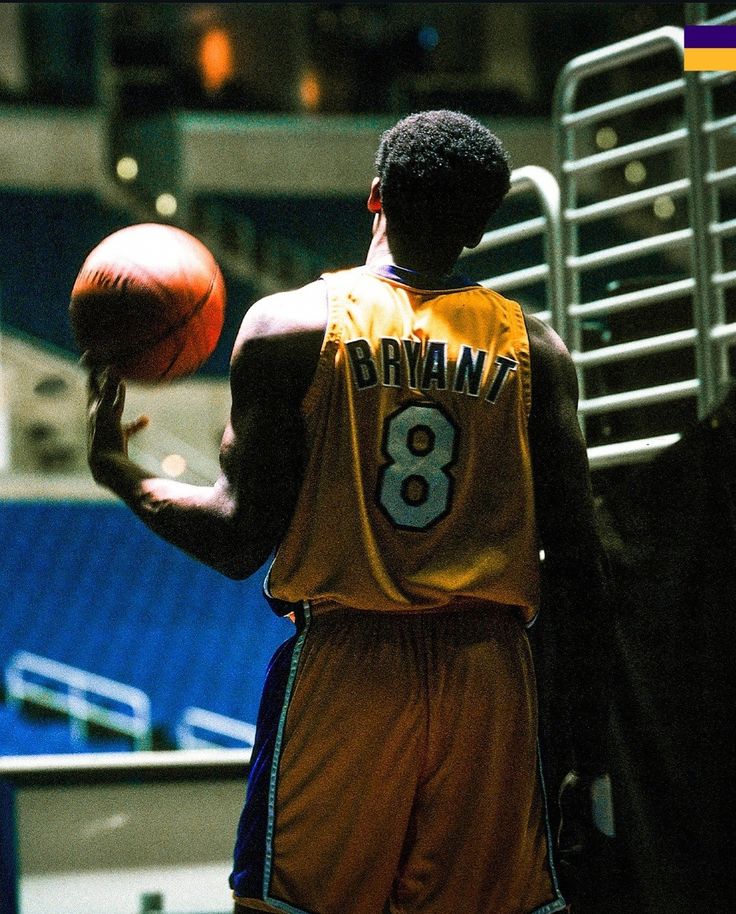 a man holding a basketball in his right hand and wearing a number on the back