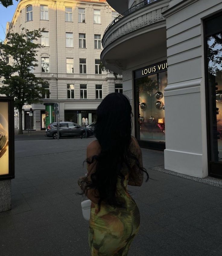 a woman walking down the street in front of a building