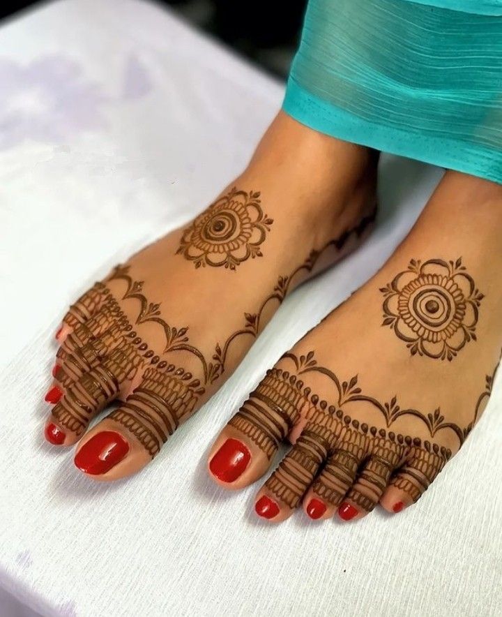 a woman's feet with henna tattoos on them