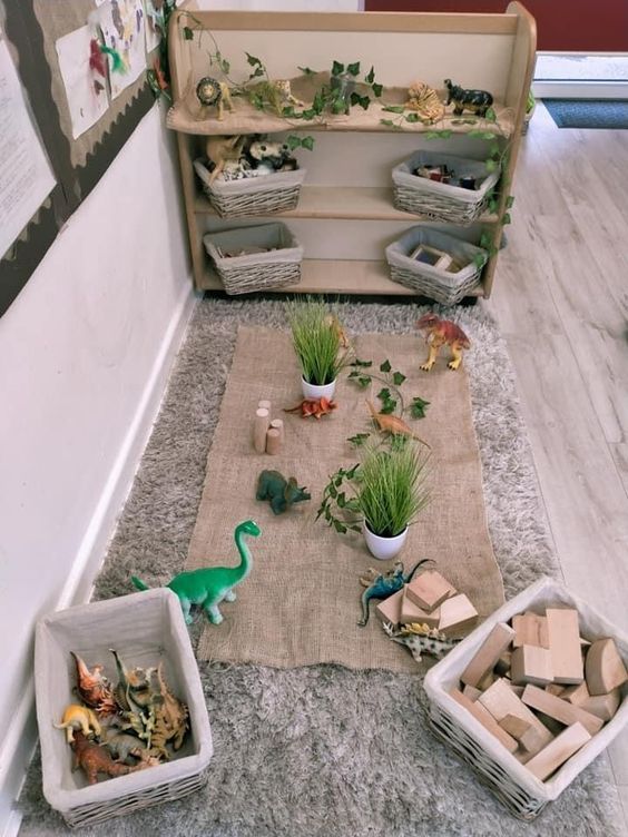 some toys are laying on the floor in front of a book shelf