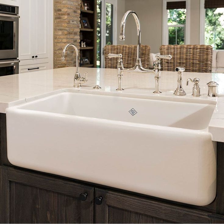 a large white sink in a kitchen next to a stove top oven and countertop