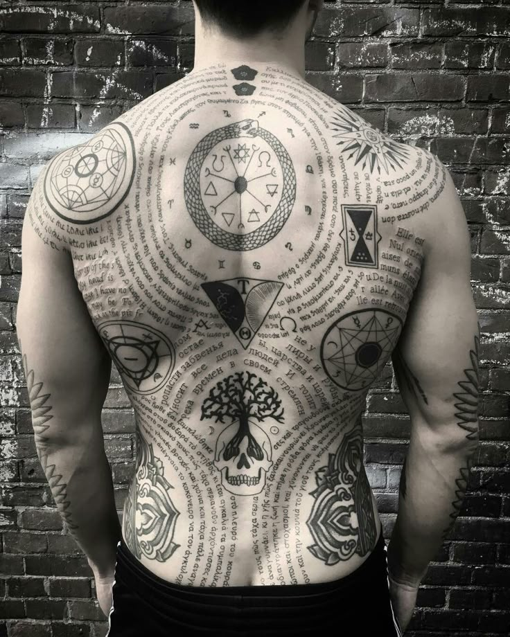 the back of a man with many different symbols on his body and chest, all over it