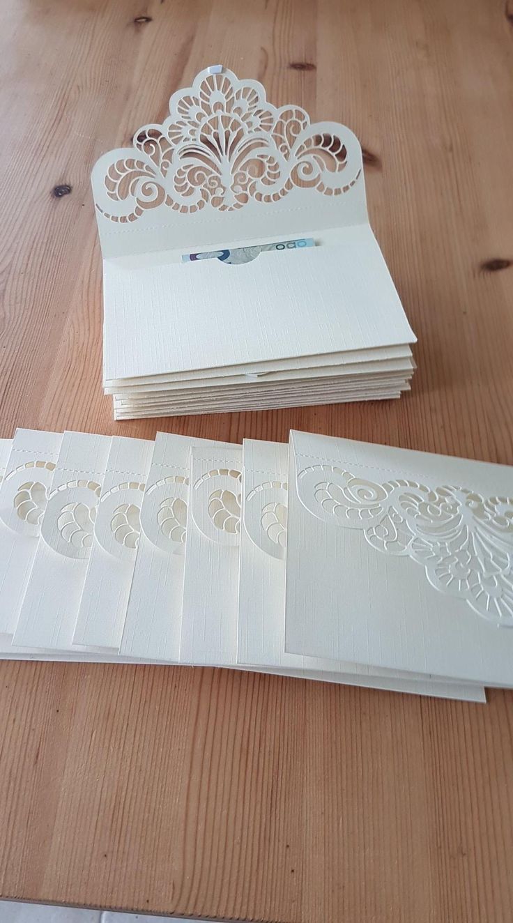 some cards are laying on a table with paper cut out to look like intricate designs