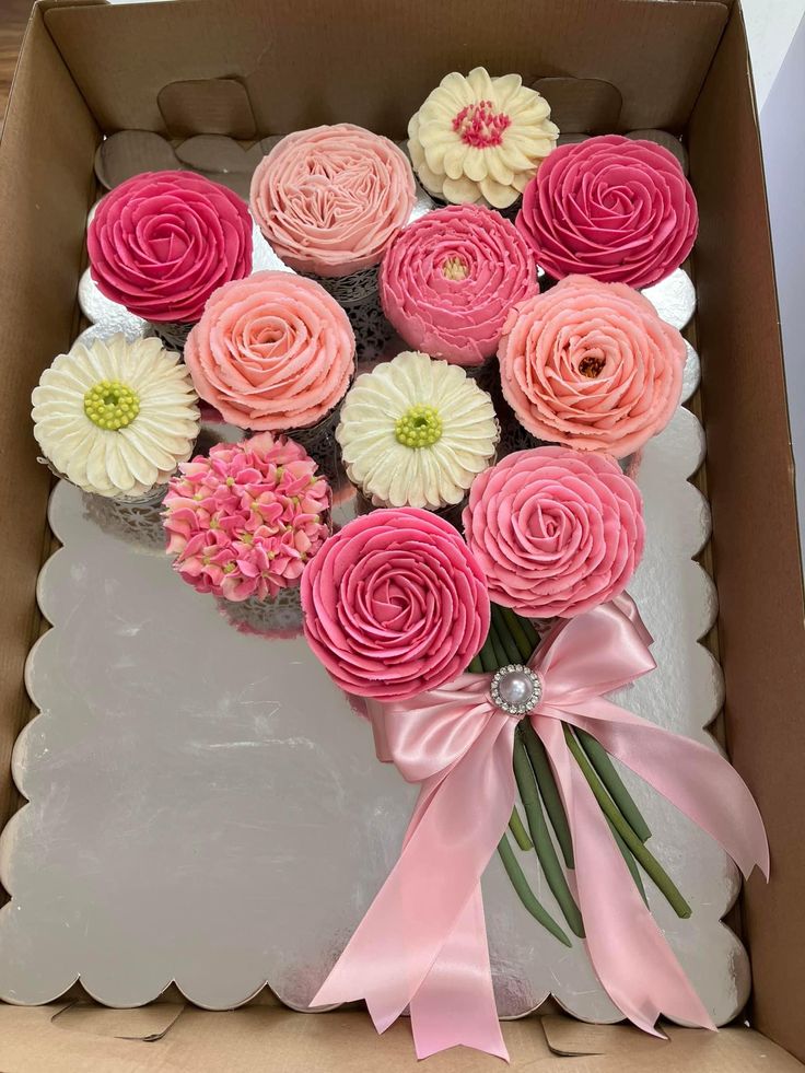 a box filled with pink and white cupcakes