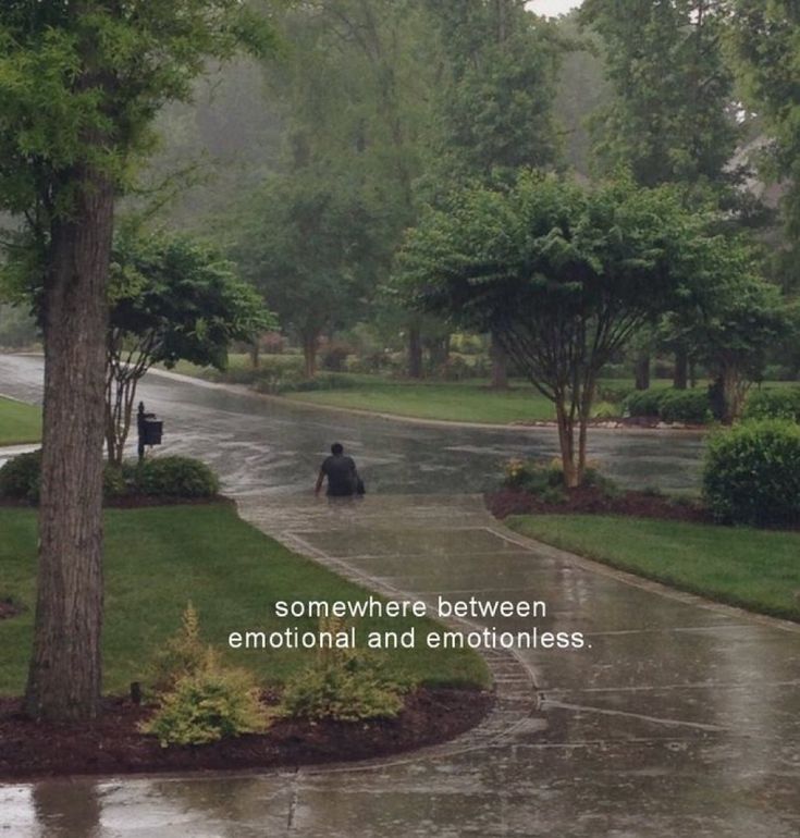 there is a man walking down the street in the rain