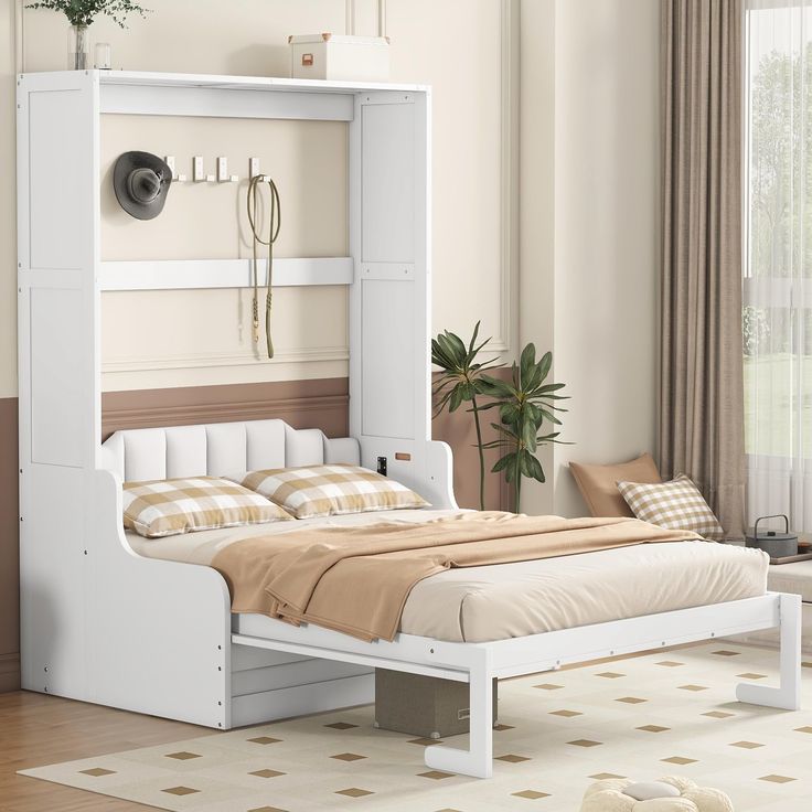 a white bed sitting in the middle of a bedroom next to a wall mounted clock