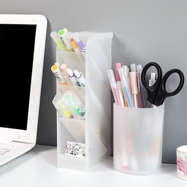 a desk with a laptop, pen holder and other office supplies next to the computer