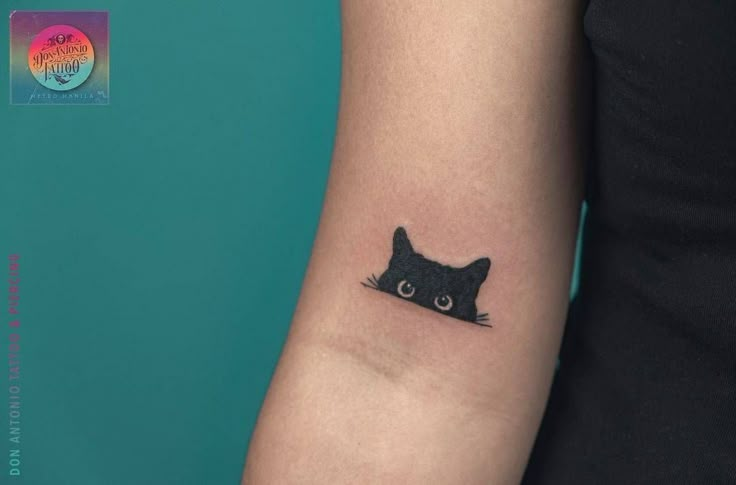 a black cat tattoo on the left arm