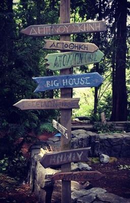 there are many signs on the post in the woods that point to different places and destinations