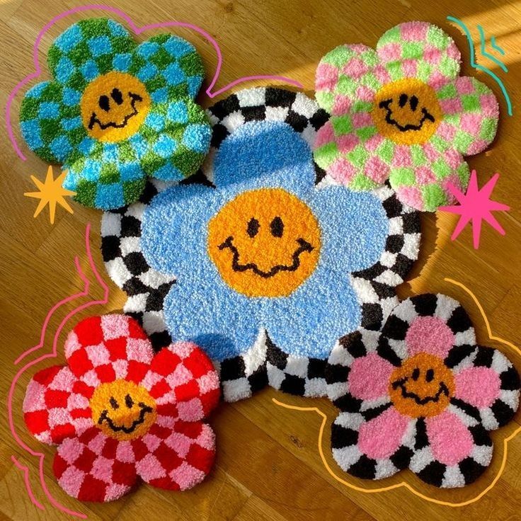 colorful rugs with smiley faces on them sitting on a wooden floor next to flowers