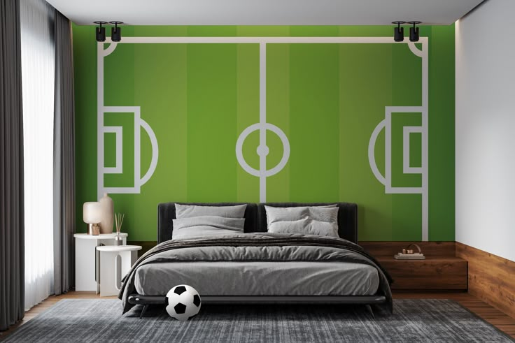 a bedroom with a soccer theme painted on the wall and a bed that has a soccer ball in front of it