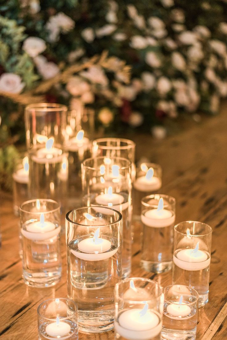 candles are lined up on a wooden table