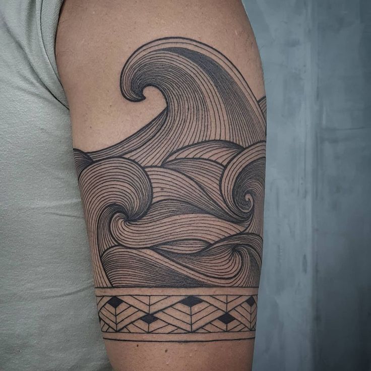 a man's arm with a wave tattoo on it