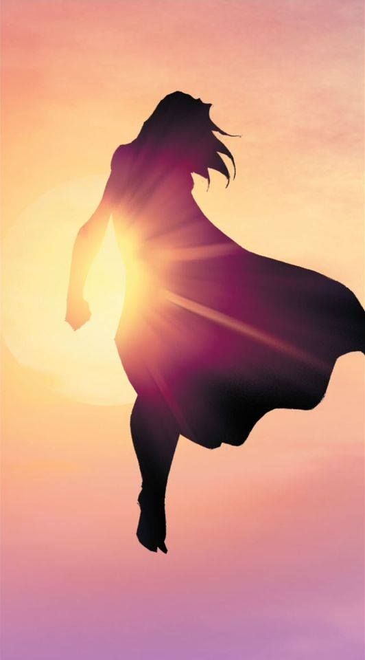 the silhouette of a woman in a cape flying through the air