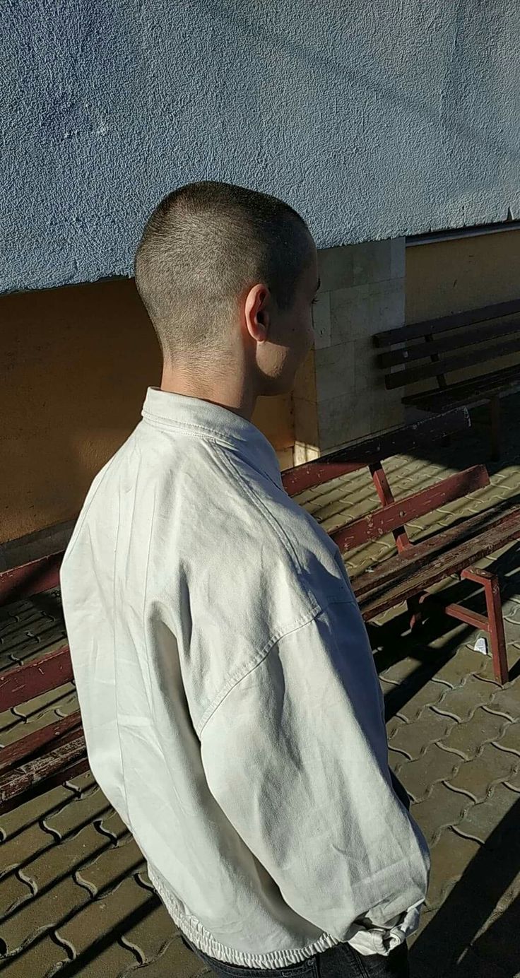 a man standing in front of a row of benches with his back to the camera