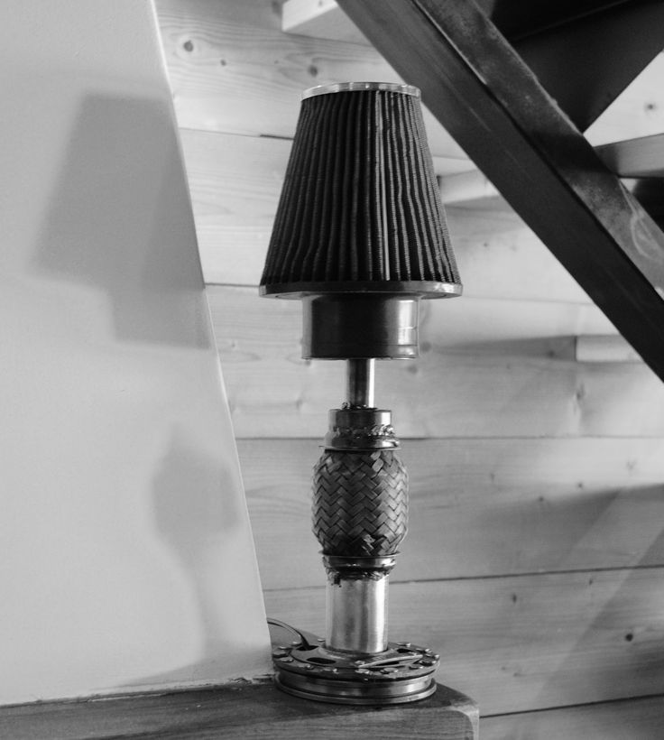 a lamp sitting on top of a wooden table next to a stair case in a room