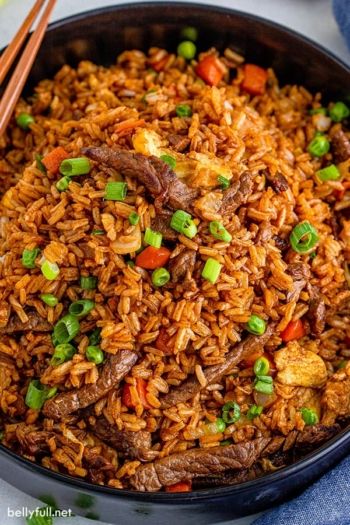 beef and rice in a skillet with chopsticks on the side, ready to be eaten