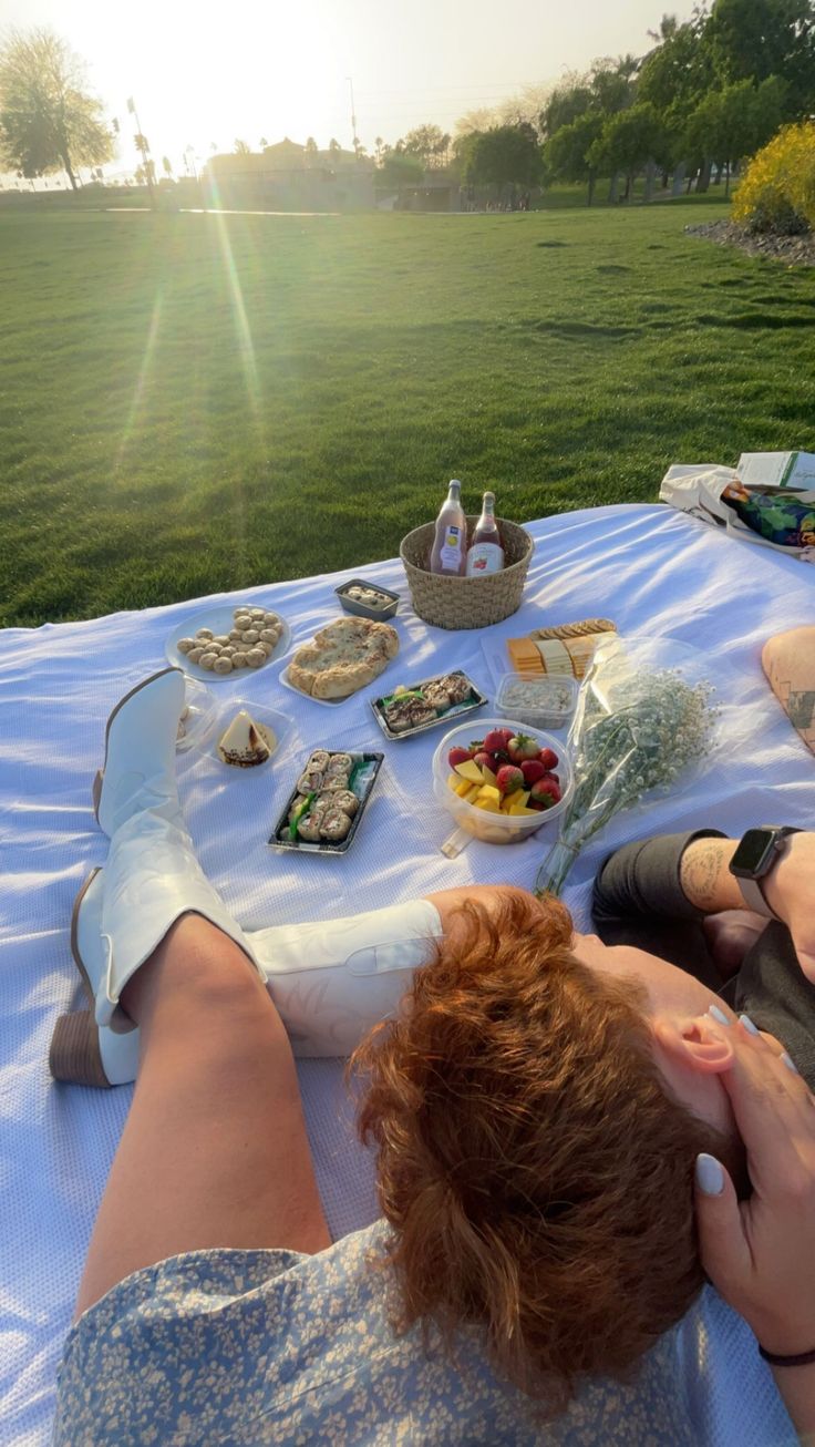 a woman laying on top of a table covered in food