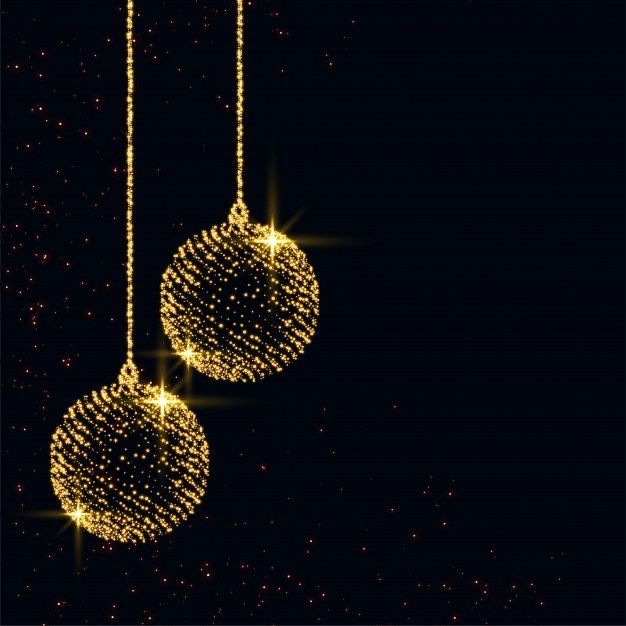 two christmas balls hanging from strings against a dark background with stars and sparkles in the air