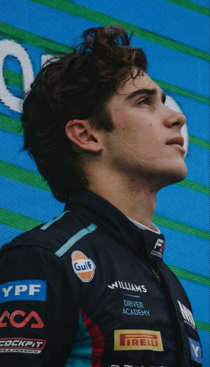 a close up of a person wearing a racing suit and looking off into the distance