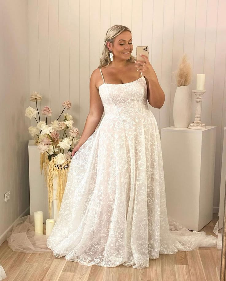 a woman is taking a selfie in her wedding dress while standing on the floor