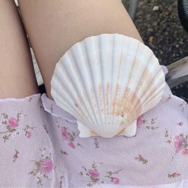 a shell is sitting on the back of a woman's leg as she sits down